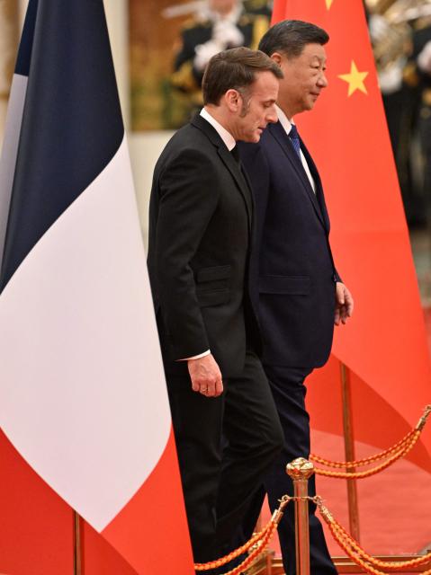 China’s President Xi Jinping (R) and France’s President Emmanuel Macron (L) walk to review honour guards during a welcome ceremony at the Great Hall of the People in Beijing on December 4, 2025. (Photo by Adek BERRY and ADEK BERRY / POOL / AFP)
