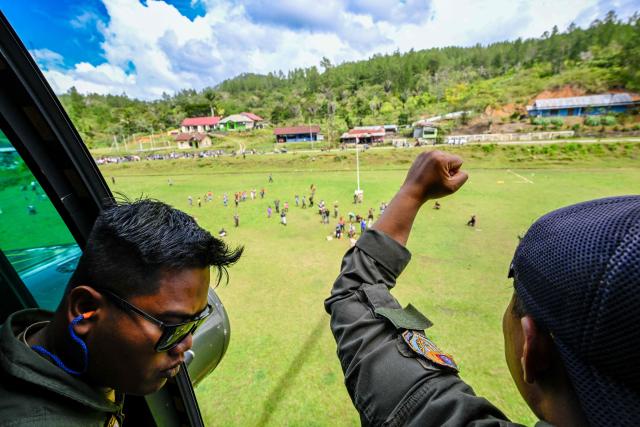 An Indonesian air force personnel gestures after unloading supplies distributed to residents in flood affected areas in Bener Meriah district, Aceh province on December 4, 2025. Rain forecasts raised fears of more damage in flood-hit Indonesia and Sri Lanka, after earlier deluges killed more than 1,500 people in four countries. (Photo by CHAIDEER MAHYUDDIN / AFP/Chaideer MAHYUDDIN / AFP)