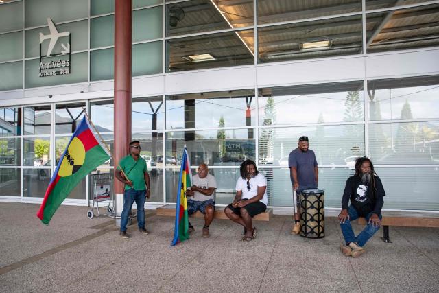 Pro-independence activist Dimitri Quenegei (3rd R) waits for the arrival of Kanak pro-independence leader Christian Tein (L), head of the CCAT (Cellule de Coordination des Actions de Terrain), at the Noumea - La Tontouta international airport in La Tontouta, south of Noumea, in France's Pacific territory of New Caledonia, on December 4, 2025. (Photo by Delphine MAYEUR / AFP)