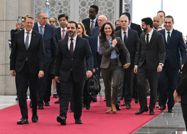 Syrian Minister of Foreign Affairs and Expatriates Asaad Al-Shaibani (front R) arrives to attend a reception with United Nations Security Council delegation at the Presidential Palace in Damascus on December 4, 2025. A United Nations Security Council delegation arrived in Syria on December 4, state media reported, the first-ever visit to the country just days before the anniversary of the ousting of longtime ruler Bashar al-Assad. The delegation arrived via the Jdeidet Yabus border crossing between Lebanon and Syria and "is scheduled to meet a number of Syrian officials" and members of civil society, state news agency SANA reported. (Photo by LOUAI BESHARA / AFP)