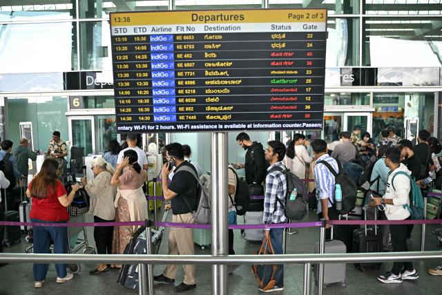 Passengers queue at a security checkpoint at Kempegowda International Airport in Bengaluru on December 4, 2025. (Photo by Idrees MOHAMMED / AFP)