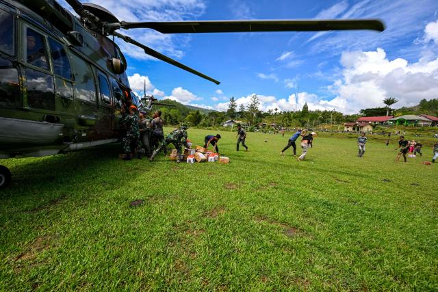 Residents carry supplies distributed by Indonesian air force personnel in flood affected areas in Bener Meriah district, Aceh province on December 4, 2025. Rain forecasts raised fears of more damage in flood-hit Indonesia and Sri Lanka, after earlier deluges killed more than 1,500 people in four countries. (Photo by CHAIDEER MAHYUDDIN / AFP/Chaideer MAHYUDDIN / AFP)
