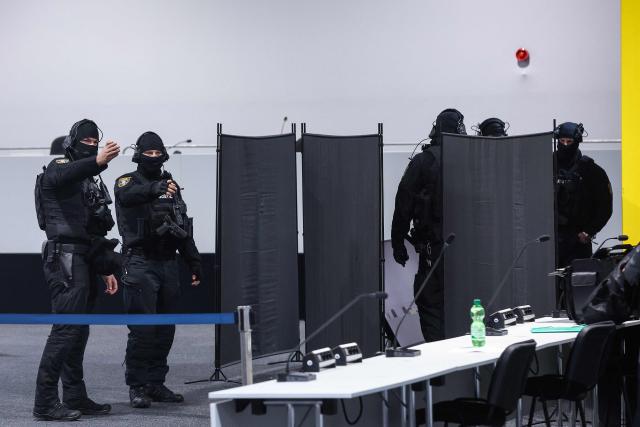 Judicial security officers set up privacy screens in front of the bulletproof glass box for Saudi Arabian defendant Taleb Jawad al-Abdulmohsen in the temporary courtroom in Magdeburg, eastern Germany on December 04, 2025, during his trial over the deadly Christmas market attack in December 2024. The Saudi doctor went on trial accused of driving an SUV through a Christmas market, killing six people and wounding more than 300. Taleb Jawad al-Abdulmohsen, a 51-year-old psychiatrist, was arrested next to the battered rental vehicle after the attack on December 20, 2024 in the eastern city of Magdeburg. (Photo by RONNY HARTMANN / AFP)