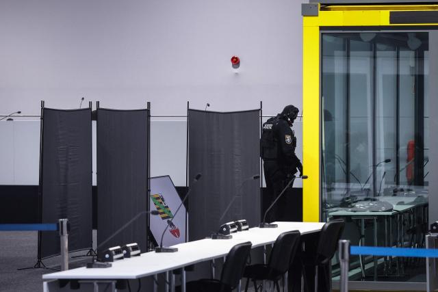 Judicial security officers set up privacy screens in front of the bulletproof glass box for Saudi Arabian defendant Taleb Jawad al-Abdulmohsen in the temporary courtroom in Magdeburg, eastern Germany on December 04, 2025, during his trial over the deadly Christmas market attack in December 2024. The Saudi doctor went on trial accused of driving an SUV through a Christmas market, killing six people and wounding more than 300. Taleb Jawad al-Abdulmohsen, a 51-year-old psychiatrist, was arrested next to the battered rental vehicle after the attack on December 20, 2024 in the eastern city of Magdeburg. (Photo by RONNY HARTMANN / AFP)