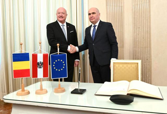 Austrian Chancellor Christian Stocker (L) shakes hands with Romania's Prime Minister Ilie Bolojan as they meet on December 4, 2025 in Vienna, Austria. (Photo by HELMUT FOHRINGER / APA / AFP) / Austria OUT