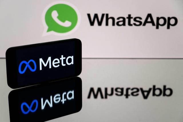 (FILES) This photograph taken on January 12, 2023 in Toulouse, southwestern France shows a smartphone and a computer screen displaying the logos of WhatsApp app and its parent company Meta. The EU said on December 4, 2025 it has opened an antitrust probe to determine if the way Meta is rolling out AI features in WhatsApp breaches the bloc's competition rules. (Photo by Lionel BONAVENTURE / AFP)