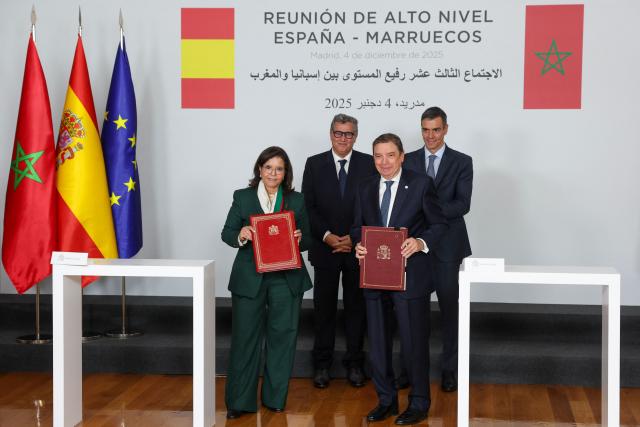 Spain's Agriculture Minister Luis Planas (R front) and Secretary of State at the Ministry of Agriculture, Fisheries and Rural Development, responsible for fisheries, Driouich Zakia (L) hold up accords during a signing ceremony attended by Spain's Prime Minister Pedro Sanchez (R) and Morocco's Prime Minister Aziz Akhannouch at the Moncloa Palace in Madrid on December 4, 2025. (Photo by Pierre-Philippe MARCOU / AFP)