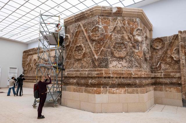Restauration experts work on the 8th Century Mshatta Facade in the Islamic Art section as renovation work continues at the Pergamon Museum, in Berlin on December 4, 2025. With the first construction phase completed, the Collection of Classical Antiquities, Museum of Islamic Art, and Museum of the Ancient Near East are expected to reopen to the public  in spring 2027. The Pergamon Museum's complete renovation is expected to be finished in 2037. (Photo by John MACDOUGALL / AFP)