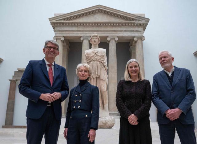 (From L) German State Minister for Culture and Media Wolfram Weimer, President of the Federal Office for Building and Regional Planning (BBR) Petra Wesseler, President of the Prussian Cultural Heritage Foundation Marion Ackermann and German architect Jan Kleihues pose in the Hellenic architecture hall in front of a statue of the Greek goddess Athena, as renovation work continues at the Pergamon Museum, in Berlin on December 4, 2025. With the first construction phase completed, the Collection of Classical Antiquities, Museum of Islamic Art, and Museum of the Ancient Near East are expected to reopen to the public  in spring 2027. The Pergamon Museum's complete renovation is expected to be finished in 2037. (Photo by John MACDOUGALL / AFP)