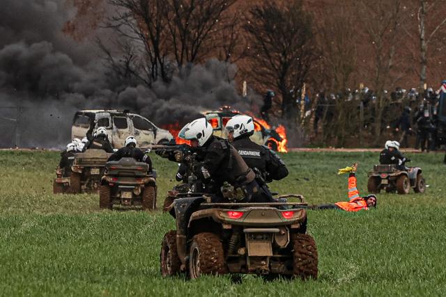 (FILES) Riot mobile gendarmes, riding quad bikes, fire blast balls at demonstrators during a demonstration called by the collective "Bassines non merci", the environmental movement "Les Soulevements de la Terre" and the French trade union 'Confederation paysanne' to protest against the construction of a new water reserve for agricultural irrigation, in Sainte-Soline, central-western France, on March 25, 2023. The public prosecutor's office opens a judicial investigation into the “direct fire” by gendarme officers during March 25, 2023's protest, on December 4, 2025. (Photo by Thibaud MORITZ / AFP)