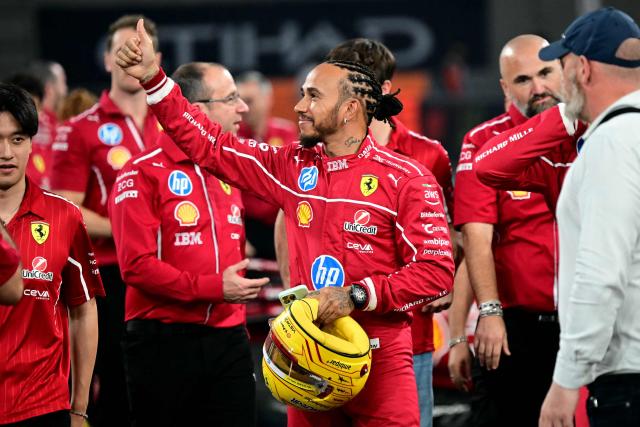 Ferrari's British driver Lewis Hamilton waves to fans after a group photo session ahead of the Abu Dhabi Formula One Grand Prix at the Yas Marina Circuit in Abu Dhabi on December 4, 2025. (Photo by Giuseppe CACACE / AFP)