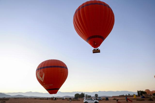 Hot air balloons fly over the Haouz plain in the the Oulad Hassoune region, a vast area north of Marrakech on December 4, 2025. (Photo by Abdel Majid BZIOUAT / AFP)