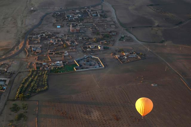 A hot air balloon flies over the Haouz plain in the the Oulad Hassoune region, a vast area north of Marrakech on December 4, 2025. (Photo by Abdel Majid BZIOUAT / AFP)