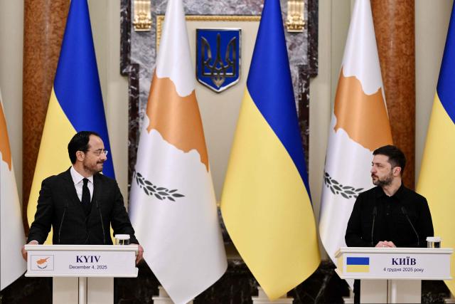 President of Ukraine Volodymyr Zelensky (R) looks at President of Cyprus Nikos Christodoulides (L) during a joint media briefing following their meeting in Kyiv on December 4, 2025, amid the Russian invasion of Ukraine. (Photo by Genya SAVILOV / AFP)
