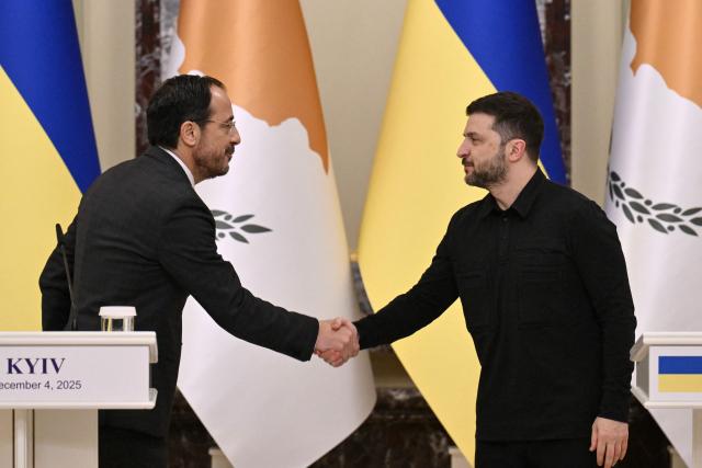 President of Ukraine Volodymyr Zelensky (R) shakes hands with President of Cyprus Nikos Christodoulides (R) during a joint media briefing following their meeting in Kyiv on December 4, 2025, amid the Russian invasion of Ukraine. (Photo by Genya SAVILOV / AFP)