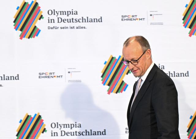 German Chancellor Friedrich Merz attends a ceremony to sign an agreement for the Olympic bid for the 2036 Summer Olympics in Berlin, on December 4, 2025. (Photo by RALF HIRSCHBERGER / AFP)