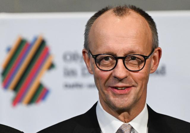 German Chancellor Friedrich Merz attends a ceremony to sign an agreement for the Olympic bid for the 2036 Summer Olympics in Berlin, on December 4, 2025. (Photo by RALF HIRSCHBERGER / AFP)
