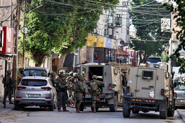 Israeli soldiers take positions during a military operation in the town of Qalqiya, in the occupied West Bank on December 4, 2025. (Photo by Zain JAAFAR / AFP)