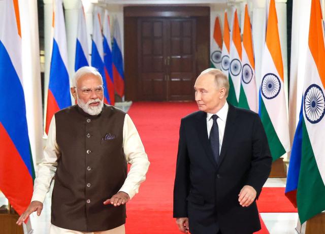 In this pool photograph distributed by the Russian state agency Sputnik, Russia's President Vladimir Putin and Indian Prime Minister Narendra Modi walk prior to an informal dinner at Modi's residence in New Delhi on December 4, 2025, the first day of the Russian leader's two-day state visit to India. (Photo by Alexander KAZAKOV / POOL / AFP)