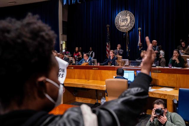 An Anti-ICE and Border Patrol protestor gestures at New Orleans Mayor-elect Helena Moreno (C) and other council members as protestors disrupt a city council meeting before being removed by New Orleans Police Department officers at City Hall in New Orleans, Louisiana, on December 4, 2025. The US Department of Homeland Security announced on December 3 it has launched a federal immigration enforcement operation, named "Operation Catahoula Crunch," in the New Orleans, Louisiana, area. (Photo by Adam GRAY / AFP)