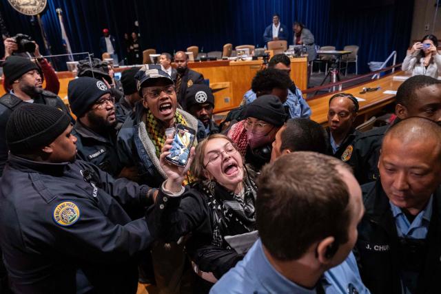 Anti-ICE and Border Patrol protestors are removed by New Orleans Police Department officers after disrupting a council meeting at City Hall in New Orleans, Louisiana, on December 4, 2025. The US Department of Homeland Security announced on December 3 it has launched a federal immigration enforcement operation, named "Operation Catahoula Crunch," in the New Orleans, Louisiana, area. (Photo by Adam GRAY / AFP)