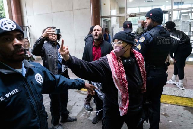 Anti-ICE and Border Patrol protestors are removed from City Hall by New Orleans Police Department officers after disrupting a city council meeting in New Orleans, Louisiana, on December 4, 2025. The US Department of Homeland Security announced on December 3 it has launched a federal immigration enforcement operation, named "Operation Catahoula Crunch," in the New Orleans, Louisiana, area. (Photo by Adam GRAY / AFP)
