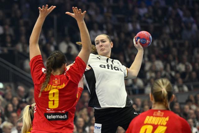 Germany's right back #77 Viola Leuchter shoots over Montenegro's left back #09 Djurdjina Jaukovic during the main round - Day 5 Group II handball match Montenegro v Germany of the IHF Women's Handball World Championship in Dortmund, western Germany on December 4, 2025. (Photo by INA FASSBENDER / AFP)