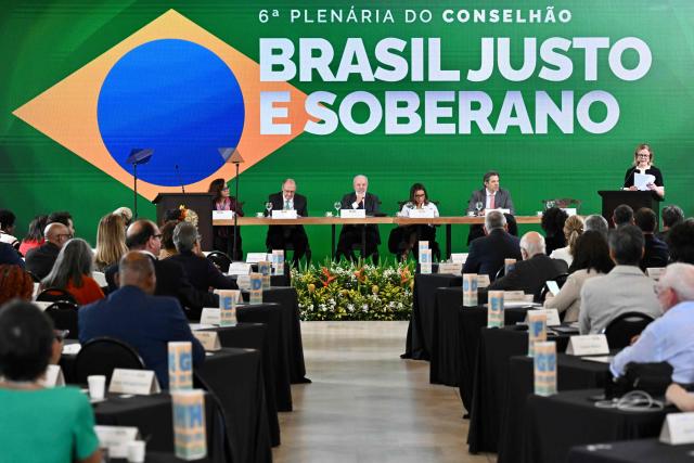 Brazil's Minister of Institutional Relations Gleisi Hoffmann (R) speaks next to Brazil’s President Luiz Inacio Lula da Silva (C), Vice-President and Minister of Industry and Trade Geraldo Alckmin (2-L), First Lady Rosangela da Silva (3-R), and Brazil's Minister of Finance Fernando Haddad, during the meeting of the Council for Sustainable Economic and Social Development at Itamaraty Palace in Brasilia, December 4, 2025. (Photo by Evaristo Sa / AFP)