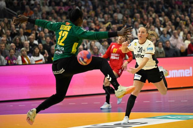 Germany's right wing #30 Jenny Behrend scores a goal during the main round - Day 5 Group II handball match Montenegro v Germany of the IHF Women's Handball World Championship in Dortmund, western Germany on December 4, 2025. (Photo by INA FASSBENDER / AFP)