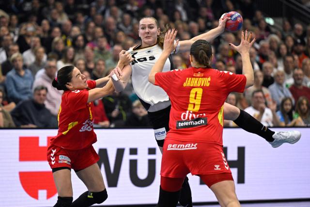 Germany's right back #77 Viola Leuchter shoots over Montenegro's left back #09 Djurdjina Jaukovic during the main round - Day 5 Group II handball match Montenegro v Germany of the IHF Women's Handball World Championship in Dortmund, western Germany on December 4, 2025. (Photo by INA FASSBENDER / AFP)