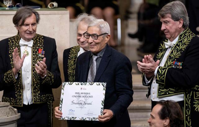 French-Algerian writer Boualem Sansal (C) poses next to member of French Academy French writer Daniel Rondeau (L), Lebanese-French author and Perpetual Secretary of the Academie Francaise Amin Maalouf (C-L) and French member of the Academie Francaise Xavier Darcos (R) after receiving the Cino del Duca Award at the Academie Francaise (French Academy), in Paris on December 4, 2025. (Photo by BERTRAND GUAY / AFP)