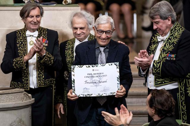 French-Algerian writer Boualem Sansal (C) poses next to member of French Academy French writer Daniel Rondeau (L), Lebanese-French author and Perpetual Secretary of the Academie Francaise Amin Maalouf (C-L) and French member of the Academie Francaise Xavier Darcos (R) after receiving the Cino del Duca Award at the Academie Francaise (French Academy), in Paris on December 4, 2025. (Photo by BERTRAND GUAY / AFP)