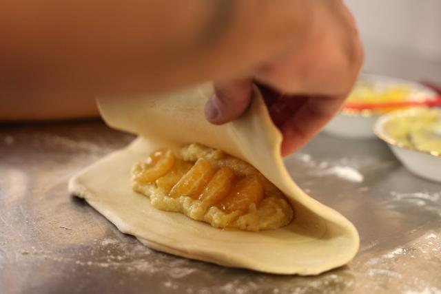 (FILES) Chef Romain Rotondi of the Rosette et Charlot restaurant cooks Corsican clementines to prepare a dessert at the restaurant in Ajaccio, on the French Mediterranean island of Corsica, on November 15, 2025. It is sweet, delicately tart and sold "le cul vert" (green bottom) with its leaves still attached: the Corsican clementine, now celebrating its 100th anniversary in 2025, is a tiny player compared to its Spanish giant counterpart, but has managed to carve out a high-end niche for itself on the French market. (Photo by Pascal POCHARD-CASABIANCA / AFP)
