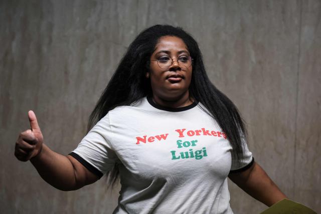 A supporter of Luigi Mangione gives a thumbs up as she arrives at Manhattan Supreme Court to attend an evidentiary hearing in the murder case of UnitedHealthcare CEO Brian Thompson, in New York, on December 4, 2025. (Photo by ANGELA WEISS / AFP)