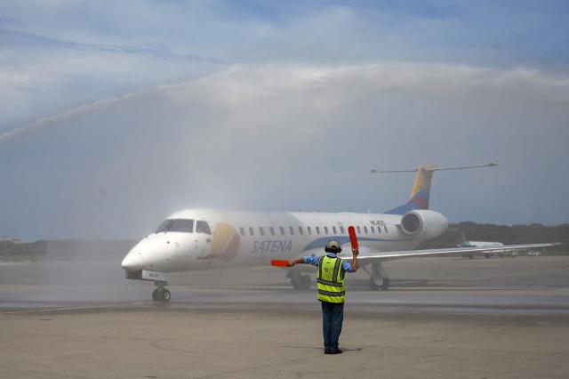 (FILES) A Satena Airlines aircraft covering the route Bogota-Caracas is given a welcoming water salute upon landing at Simon Bolivar International Airport in Maiquetia, La Guaira State, Venezuela, on November 9, 2022. Colombian state-owned airline Satena announced the suspension of flights to Venezuela on December 4, 2025, due to “interference” in navigation systems, amid US bombings in the Caribbean and threats of a ground offensive. (Photo by Federico PARRA / AFP)