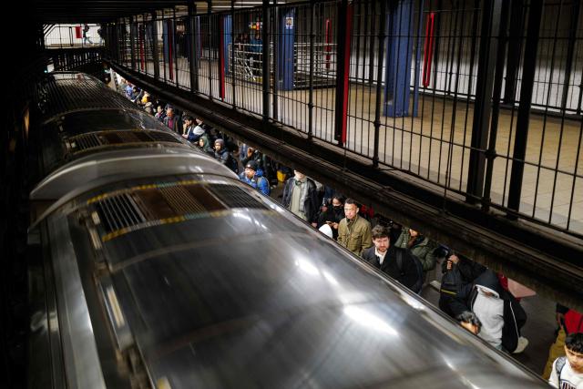 People are seen standing on a platform as a subway train arrive at station in New York City on December 4, 2025. (Photo by CHARLY TRIBALLEAU / AFP)