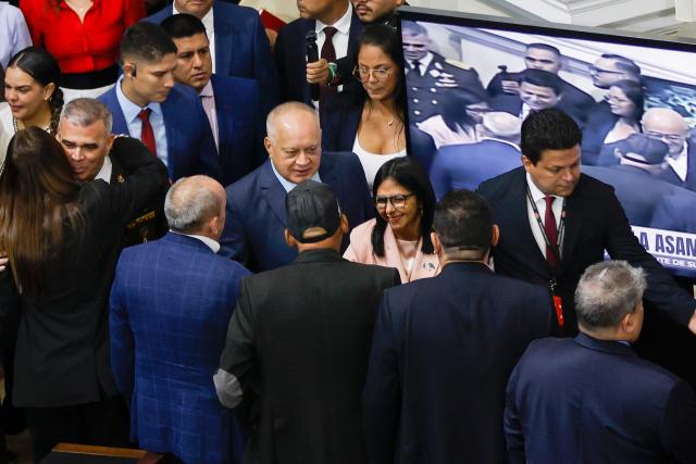 Venezuela's Minister of Interior Relations, Justice and Peace, Diosdado Cabello (C-L), and Vice President Delcy Rodriguez (C-R) arrive for the presentation of the 2026 fiscal year budget at the National Congress in Caracas on December 4, 2025. (Photo by Pedro MATTEY / AFP)