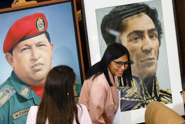 Venezuela's Vice President Delcy Rodriguez gestures past portraits of late Venezuelan President Hugo Chavez and the liberator Simon Bolivar during the presentation of the 2026 fiscal year budget at the National Congress in Caracas on December 4, 2025. (Photo by Pedro MATTEY / AFP)