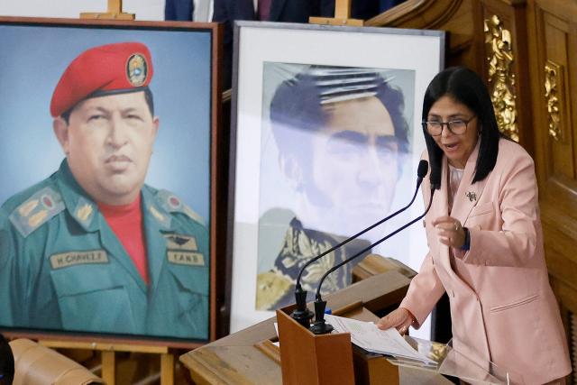 Venezuela's Vice President Delcy Rodriguez speaks past portraits of late Venezuelan President Hugo Chavez and the liberator Simon Bolivar during the presentation of the 2026 fiscal year budget at the National Legislative Congress in Caracas on December 4, 2025. (Photo by Pedro MATTEY / AFP)