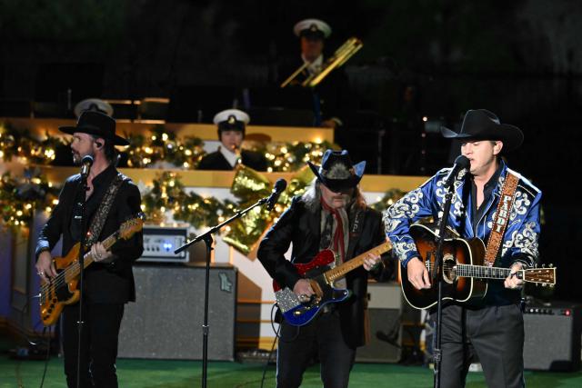 US country singer Jon Pardi (R) performs with his band during the National Christmas Tree Lighting at the Ellipse in Washington, DC, on December 4, 2025. (Photo by ANDREW CABALLERO-REYNOLDS / AFP)
