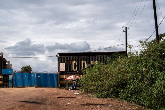 A general view of the main entrance to the Congo Dongfang Mining (CDM), a Chinese company based in Lubumbashi, in the south of the Democratic Republic of Congo, 24 November 2025. Her parched field is overrun with debris carried by polluted waters, and the little girl in his arms is covered in sores: in Lubumbashi, the mining capital of the DRC, thousands of Congolese claim to be victims of toxic waste from the mining industry. Hélène Mvubu recounts enduring for years the effects of floods caused by contaminated water discharged by Congo Dongfang Mining (CDM), a Chinese mining company that processes copper and cobalt ores in the outskirts of the capital of Katanga province, in the southeastern Democratic Republic of Congo (DRC). (Photo by Glody MURHABAZI / AFP)