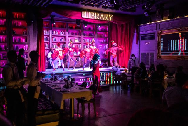(FILES) Dancers perform on stage as patrons sit at tables inside The Library restaurant and club in Lagos, on September 6, 2025. Scantily clad in a sequin leotard and silver heels, the dancer swayed to "Money" by Cardi B in a mega-sized cocktail glass.
Nigeria might be going through its worst economic crisis in a generation, but in Lagos, the party hasn't stopped.
Patrons at The Library, where fake banknotes rained down on the stage, were being treated to both dinner and a show as cabaret takes the mega-city by storm.
Clubs like The Library have been fully revamped to cash in on the trend, tapping into the best singers and dancers across the African cultural powerhouse, but also drawing talent from across the world. (Photo by OLYMPIA DE MAISMONT / AFP)