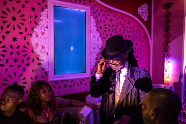 (FILES) Nigerian professional magician, Felven Brain, performs in front of patrons sitting at a table at the Zaza restaurant and lounge in Lagos, on August 24, 2025. Scantily clad in a sequin leotard and silver heels, the dancer swayed to "Money" by Cardi B in a mega-sized cocktail glass.
Nigeria might be going through its worst economic crisis in a generation, but in Lagos, the party hasn't stopped.
Patrons at The Library, where fake banknotes rained down on the stage, were being treated to both dinner and a show as cabaret takes the mega-city by storm.
Clubs like The Library have been fully revamped to cash in on the trend, tapping into the best singers and dancers across the African cultural powerhouse, but also drawing talent from across the world. (Photo by OLYMPIA DE MAISMONT / AFP)