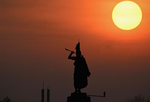 The sun sets behind the Monument to Cuauhtemoc, inaugurated in 1887 and dedicated to the last Mexica indigenous ruler of of Tenochtitlan in Mexico City on December 4, 2025. (Photo by Yuri CORTEZ / AFP)