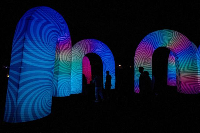 Visitors enjoy the Brilla Light Festival as part of Christmas celebrations in Bogota on December 4, 2025. (Photo by Luis ACOSTA / AFP)