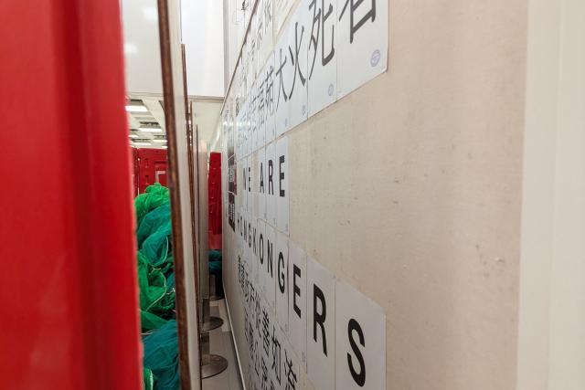 A message on the student union-run notice board, nicknamed “democracy wall”, is seen behind barricades at Hong Kong Baptist University in Hong Kong on December 3, 2025. A Hong Kong university ordered its student union to shut down after a message was posted on campus expressing condolences and urging justice for the victims of a major fire, according to a letter publicly shared on December 5. A message expressing condolences and urging justice for the victims in a deadly fire at Wang Fuk Court was seen on the notice board before it was blocked off. (Photo by Holmes CHAN / AFP)