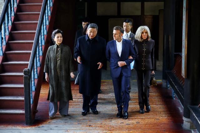 French President Emmanuel Macron (2nd R), his wife Brigitte Macron (R), Chinese President Xi Jinping (2nd L) and his wife Peng Liyuan (L) visit the Dujiangyan site, a designated UNESCO World Heritage site, in Dujiangyan, in southwestern China's Sichuan province on December 5, 2025. (Photo by Sarah Meyssonnier / POOL / AFP)