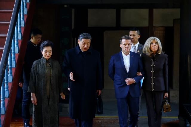 French President Emmanuel Macron (2nd R), his wife Brigitte Macron (R), Chinese President Xi Jinping (2nd L) and his wife Peng Liyuan (L) visit the Dujiangyan site, a designated UNESCO World Heritage site, in Dujiangyan, in southwestern China's Sichuan province on December 5, 2025. (Photo by Sarah Meyssonnier / POOL / AFP)