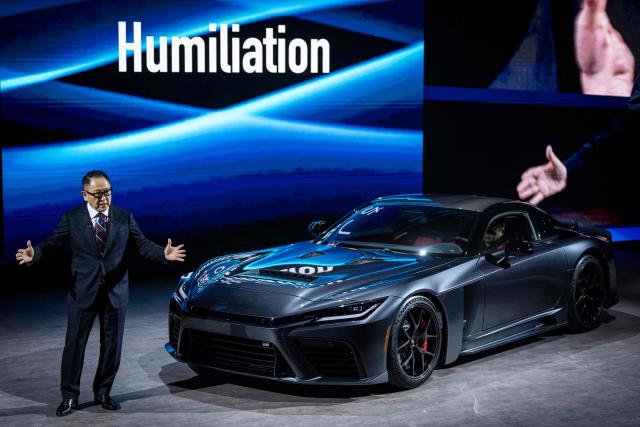 Toyota Motor Corporation Board Chairman Akio Toyoda delivers a speech next to the prototype model 'GR GT' during the company’s all-new sports models World Premiere at the Toyota Woven City in Susono, Shizuoka prefecture on December 5, 2025. (Photo by Yuichi YAMAZAKI / AFP)