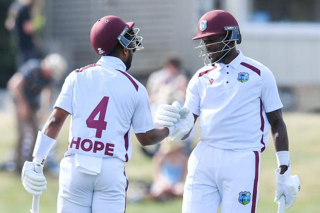 West Indies' Shai Hope (L) is congratulated by Justin Greaves after scoring a century during day four of the first Test cricket match between New Zealand and West Indies at Hagley Oval in Christchurch on December 5, 2025. (Photo by Sanka Vidanagama / AFP)